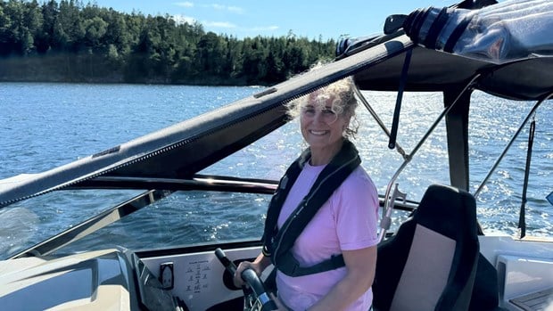 Helen kör sin motorbåt och ser glad ut
