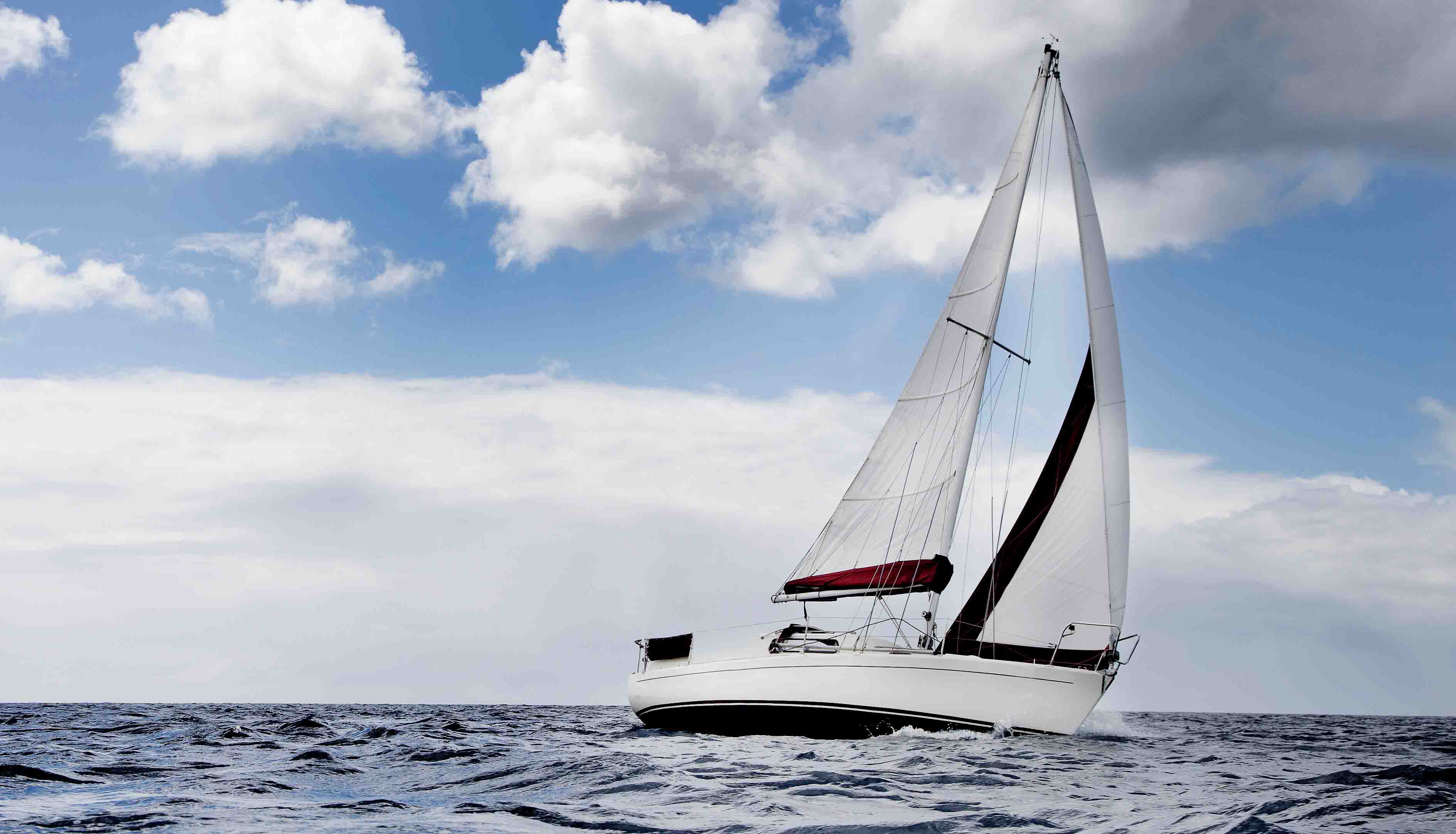 Segelbåt på tur i havet en dag med växlande molnighet