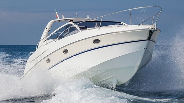 Vit båt som åker på vattnets vågor