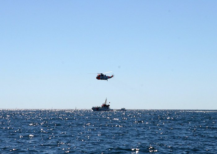 Helikopter flyger ovanför båt